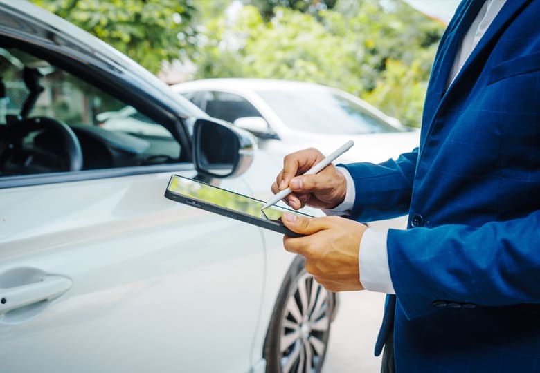 車の前でタブレットを操作